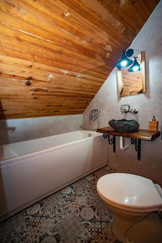 a bathroom with a white tub and a toilet at Rustic Home Tara in Kaludjerske Bare