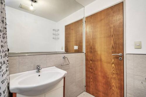baño con lavabo y puerta de madera en Rent Cramer en Buenos Aires