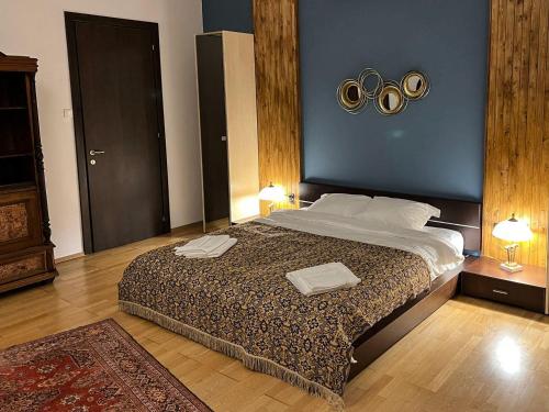 1 dormitorio con 1 cama grande y 2 toallas. en Villa & SPA 4Temporadas - Plaiul Foii en Zărneşti
