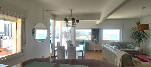 een woonkamer met een bank en een eetkamer bij Vista y ubicación imperdible en Punta del Este. in Punta del Este