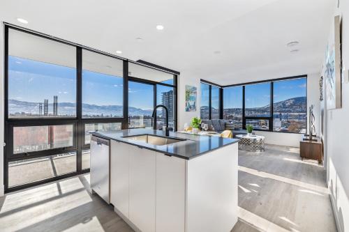 a kitchen with a sink and large windows at Brand New Luxury Downtown Near the Beach #10 in Kelowna
