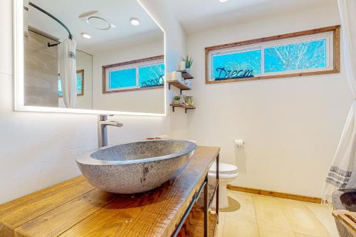 La salle de bains est pourvue d'un grand lavabo en pierre sur un comptoir en bois. dans l'établissement Bluebonnet Bungalow, à Austin