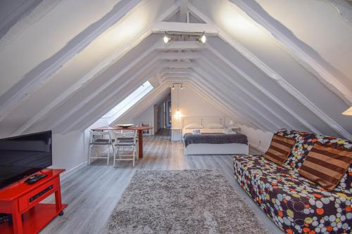 a attic living room with a bed and a couch at Bica Loft in Lisbon