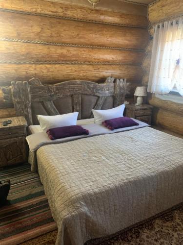 a bedroom with a large bed with a wooden wall at Popas Regal 
