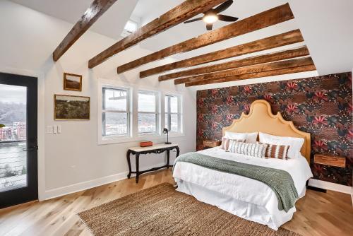 a bedroom with a large bed with a floral accent wall at Urban Oasis Retreat With Luxury Design, Hot Tub, Fire Pit, Breathtaking Downtown & River Views in Pittsburgh
