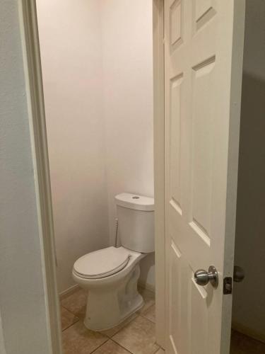 a bathroom with a toilet and a white door at Lovely Downtown Room #2 no smoking no kids second floor in Houston