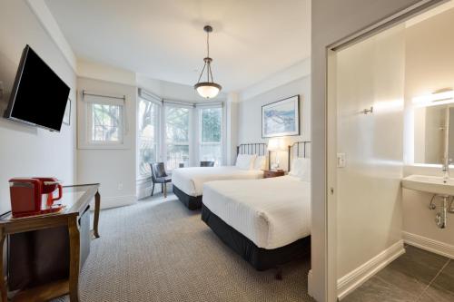 a hotel room with two beds and a sink at The Grove Inn in San Francisco