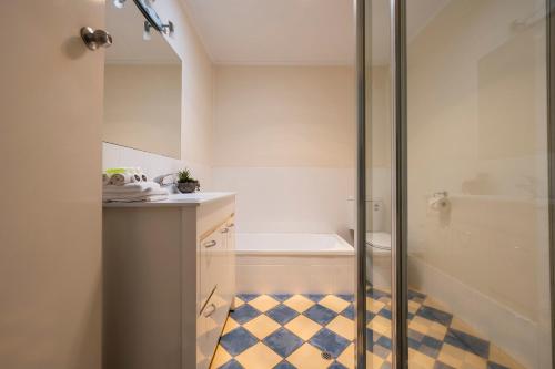 a bathroom with a shower stall and a tub at Four Beaches-LJHooker Yamba in Yamba