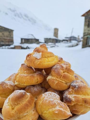 a pile of donuts sitting on top of a plate at Chvibiani Guesthouse & Bar in Ushguli