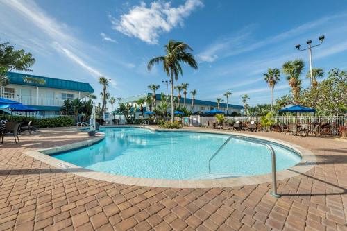 a swimming pool at a resort with palm trees at Best Western Cocoa Beach Hotel & Suites in Cocoa Beach