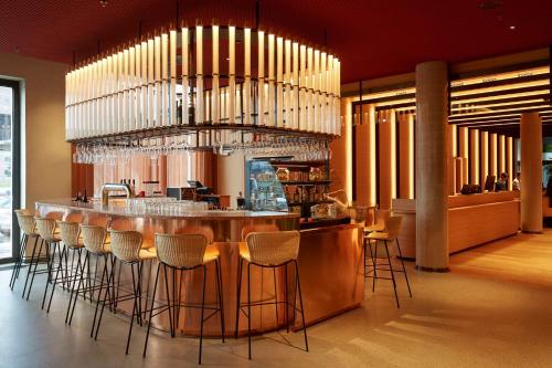 een restaurant met een bar met krukken in een kamer bij Scandic Frankfurt Hafenpark in Frankfurt am Main