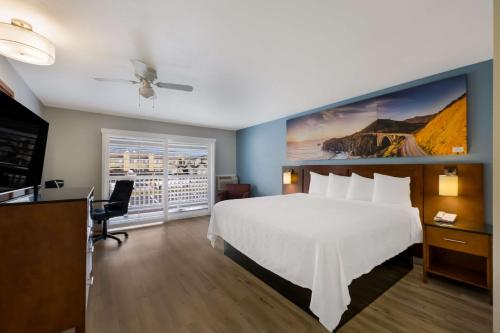 a hotel room with a large white bed and a window at Pacific Coast Roadhouse Hotel in San Simeon