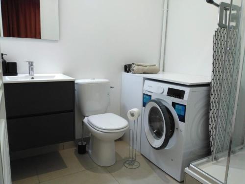 ein Badezimmer mit einem WC und einer Waschmaschine in der Unterkunft Métal studio in Cachan