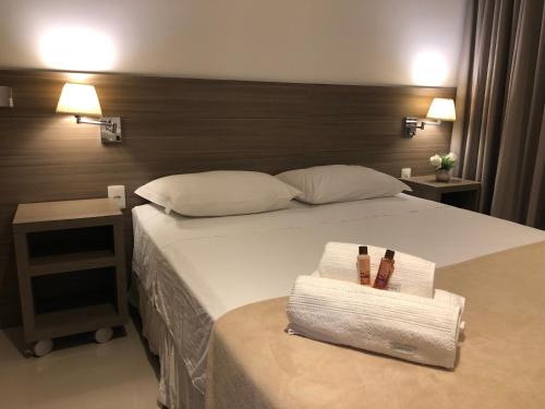 a bedroom with a bed with two towels and two lamps at Apto tipo Flat Midas Riocentro - Barra da Tijuca- Barra olímpica in Rio de Janeiro