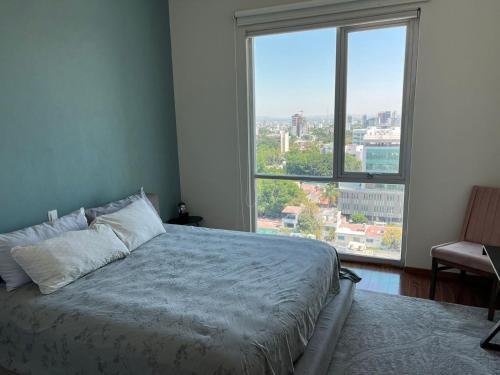 a bedroom with a bed and a large window at Penthouse Minerva in Guadalajara