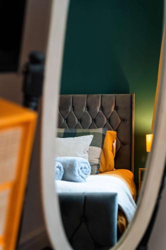 a reflection of a bed in a mirror at Luxury Renovated Bungalow with wheel chair access, Hot Tub and Fire Pit in Wouldham