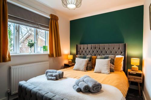 a bedroom with a large bed with a green wall at Luxury Renovated Bungalow with wheel chair access, Hot Tub and Fire Pit in Wouldham