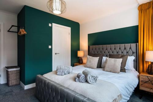 a bedroom with a large bed with a green wall at Luxury Renovated Bungalow with wheel chair access, Hot Tub and Fire Pit in Wouldham