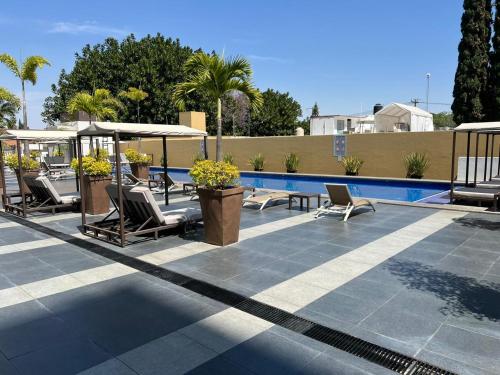 a patio with chairs and a swimming pool at Penthouse Minerva in Guadalajara