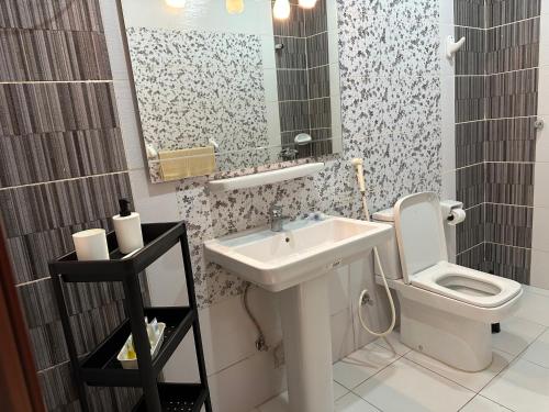 a bathroom with a sink and a toilet and a mirror at H.H apartments شقق مفروشة in Makkah