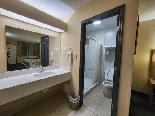 y baño con lavabo y aseo. en Budget Host Inn, en Henderson