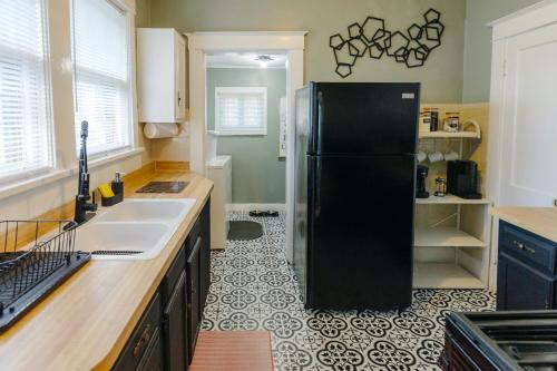 a kitchen with a black refrigerator in a room at Historic Revival 2BR Midtown Memphis Free Parking Fast Wifi Free Parking Yes Pets in Memphis