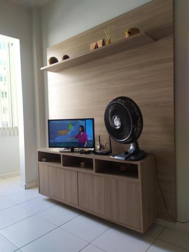 a living room with a fan and a television at Quarto e Sala completo in Rio de Janeiro
