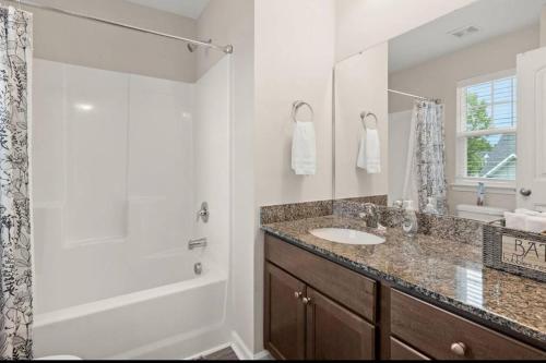 a bathroom with a tub and a sink and a shower at Quiet & Comfy Townhouse - Close to Charleston in Charleston