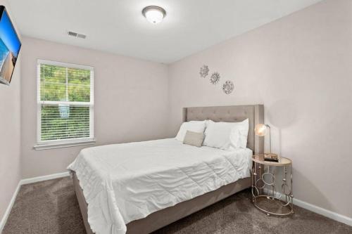 a white bedroom with a bed and a window at Quiet & Comfy Townhouse - Close to Charleston in Charleston