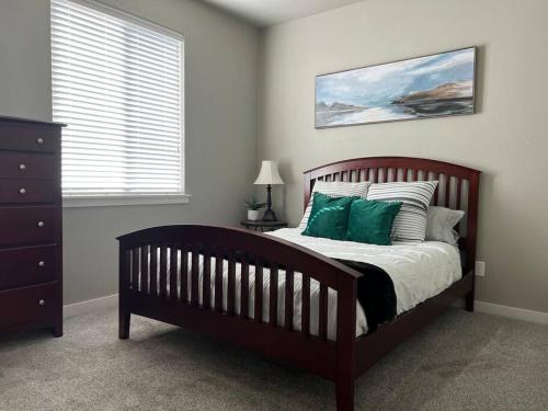 ein Schlafzimmer mit einem Holzbett mit grünen Kissen in der Unterkunft Great Location! Modern 3 BR - Wifi - Netflix in Meridian