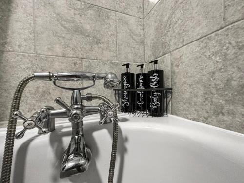 a bath tub with a faucet in a bathroom at 3 bed home in Tonypandy with Balcony View Room in Llwyn-y-pia