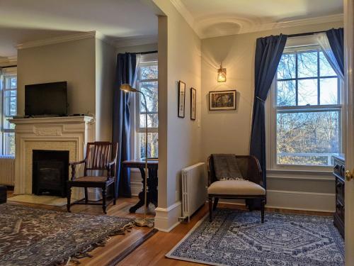 a living room with two chairs and a fireplace at Stanton House Inn in Greenwich