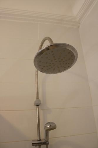 a shower with a shower head in a bathroom at The Rink Apartment's in Sukuta