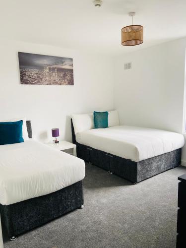 two beds sitting next to each other in a room at Beautiful 4 Bedroom 2 bathroom House close to city centre in Leeds