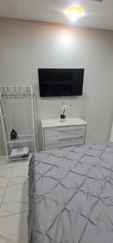 a bedroom with a bed and a flat screen tv at El Rincón in Tunapuna