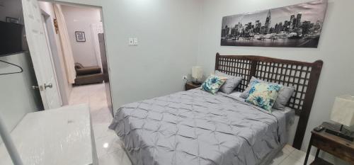 a bedroom with a bed and a painting on the wall at El Rincón in Tunapuna