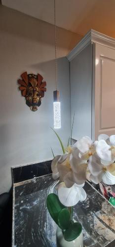 a vase with white flowers sitting on a table at El Rincón in Tunapuna