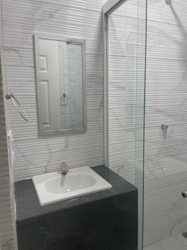 a bathroom with a sink and a glass shower at Hotel Sabana Inn in San José
