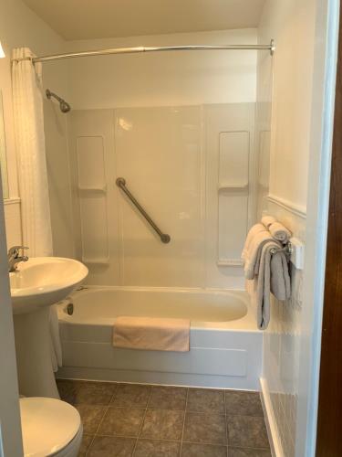 a bathroom with a shower and a tub and a sink at Tete Jaune Lodge in Tête Jaune Cache