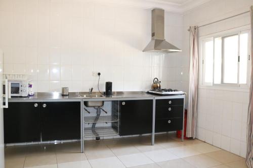 a kitchen with a sink and a counter top at The Rink Apartment's in Sukuta