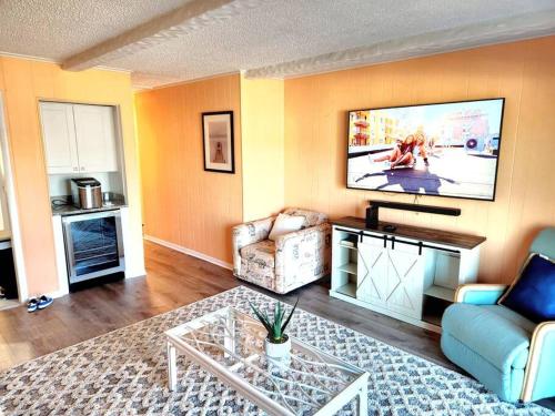 a living room with a couch and a tv on the wall at Spacious 2 Bedroom and 2 Baths in Ocean City