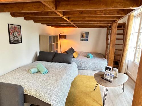 2 camas en una habitación con sofá y mesa en MD Apartment Terrace - Disneyland Paris, en Serris