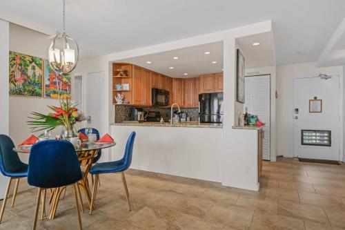 a kitchen and dining room with a table and blue chairs at Sapphire Oasis- Heavenly Ocean View and Resort in Kahana
