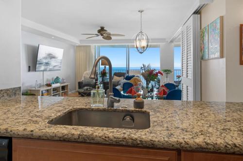 eine Küche mit einem Waschbecken und ein Wohnzimmer in der Unterkunft Sapphire Oasis- Heavenly Ocean View and Resort in Kahana