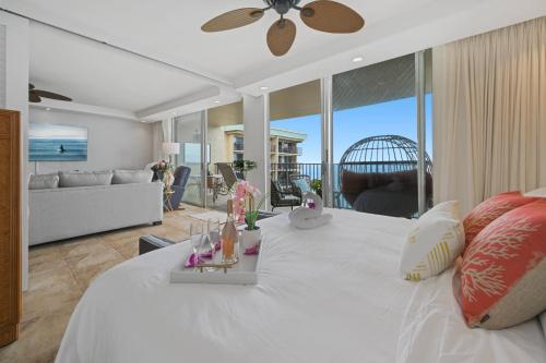 a bedroom with a white bed and a living room at Sapphire Oasis- Heavenly Ocean View and Resort in Kahana