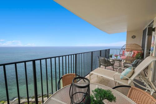 a balcony with a table and chairs and the ocean at Sapphire Oasis- Heavenly Ocean View and Resort in Kahana
