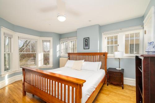 a bedroom with a wooden bed and windows at Harriet House in Minneapolis