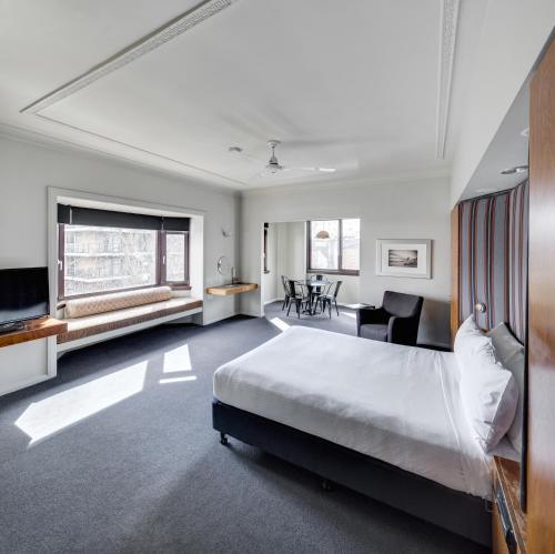 ein Schlafzimmer mit einem großen Bett und einem Schreibtisch in der Unterkunft Regents Court Sydney in Sydney