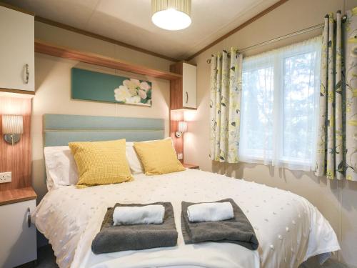 a bedroom with a large bed with two pillows on it at Marlow Lodge in Hyssington