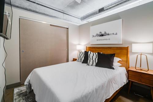 um quarto com uma grande cama branca e uma televisão em Sable 74 - One Bedroom em Minneapolis